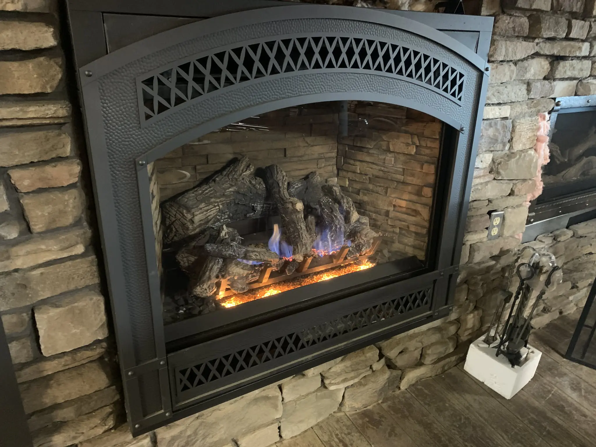 Stone surround gas fireplace with glowing flames