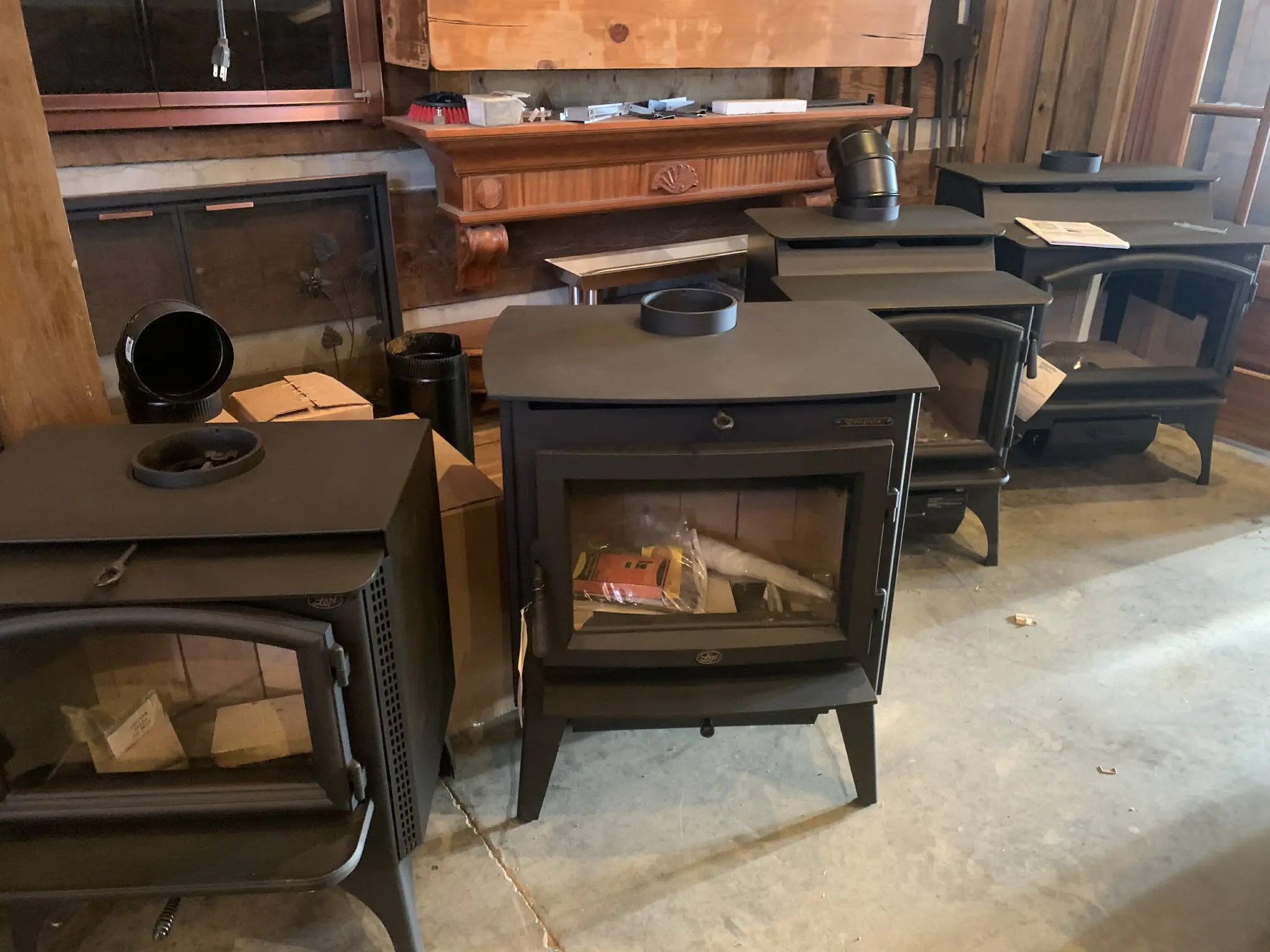 Row of black wood stoves in showroom
