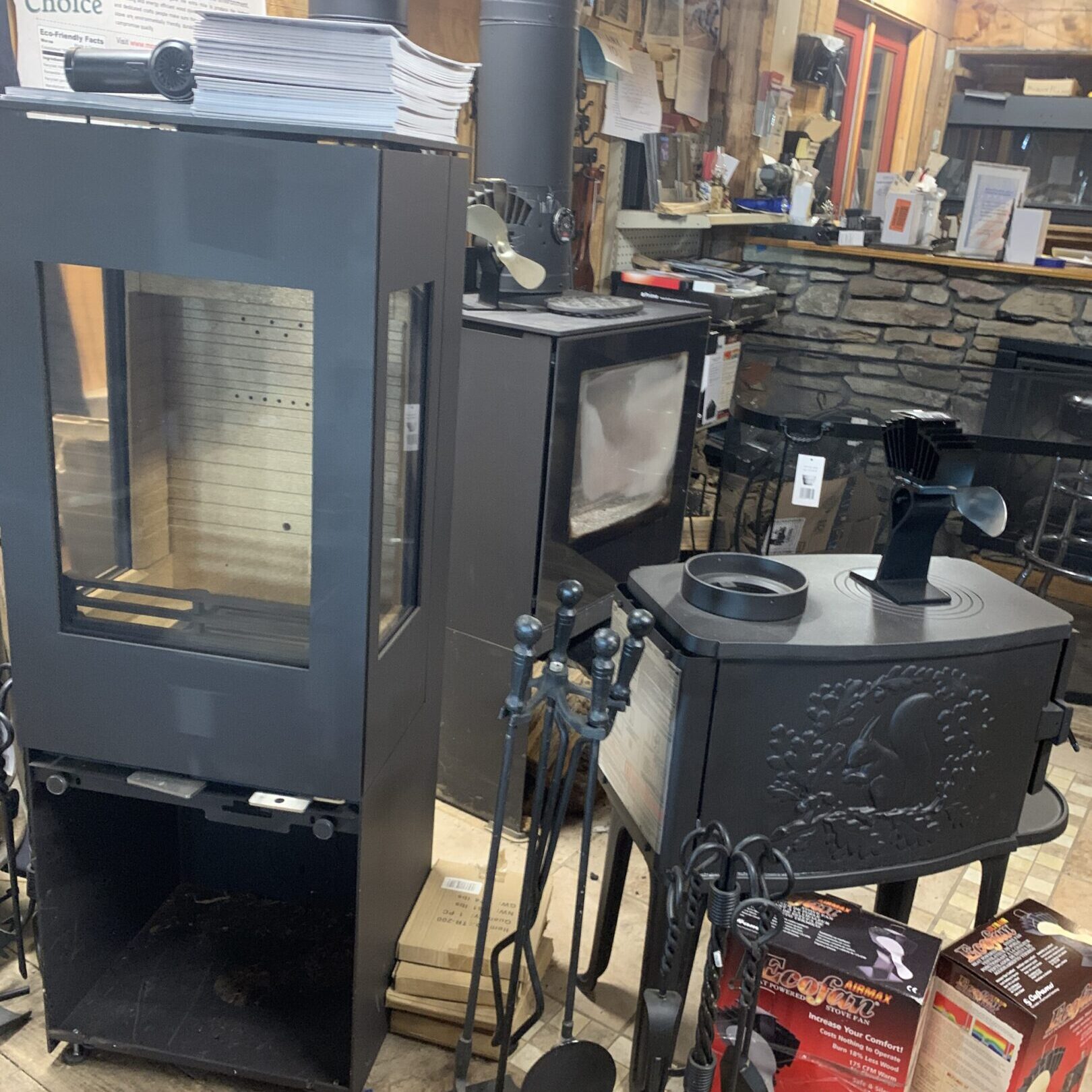 Two black wood stoves with fireplace tools